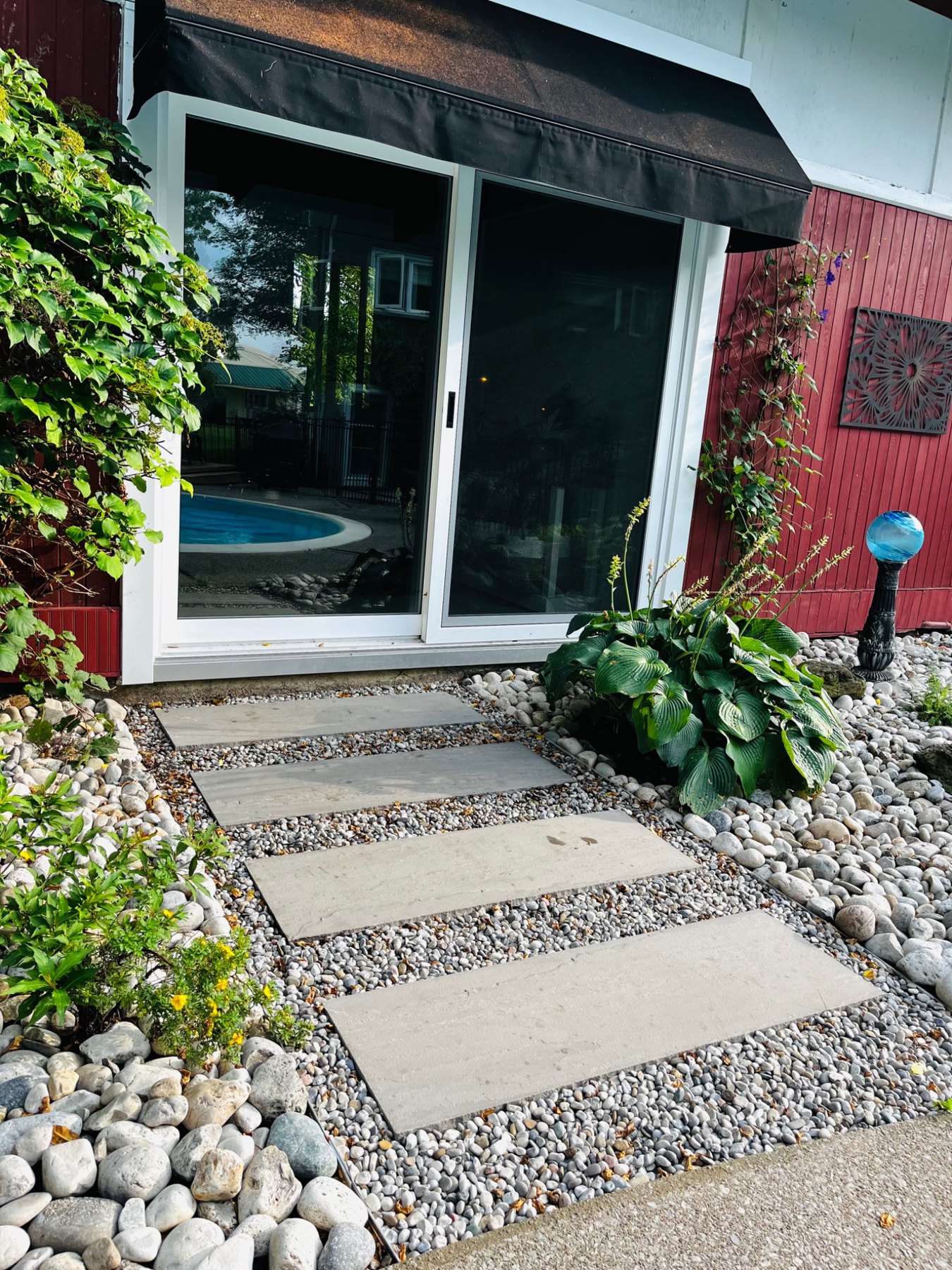 After: natural-stone stepping walkway with pea gravel infill and river-stone garden borders
