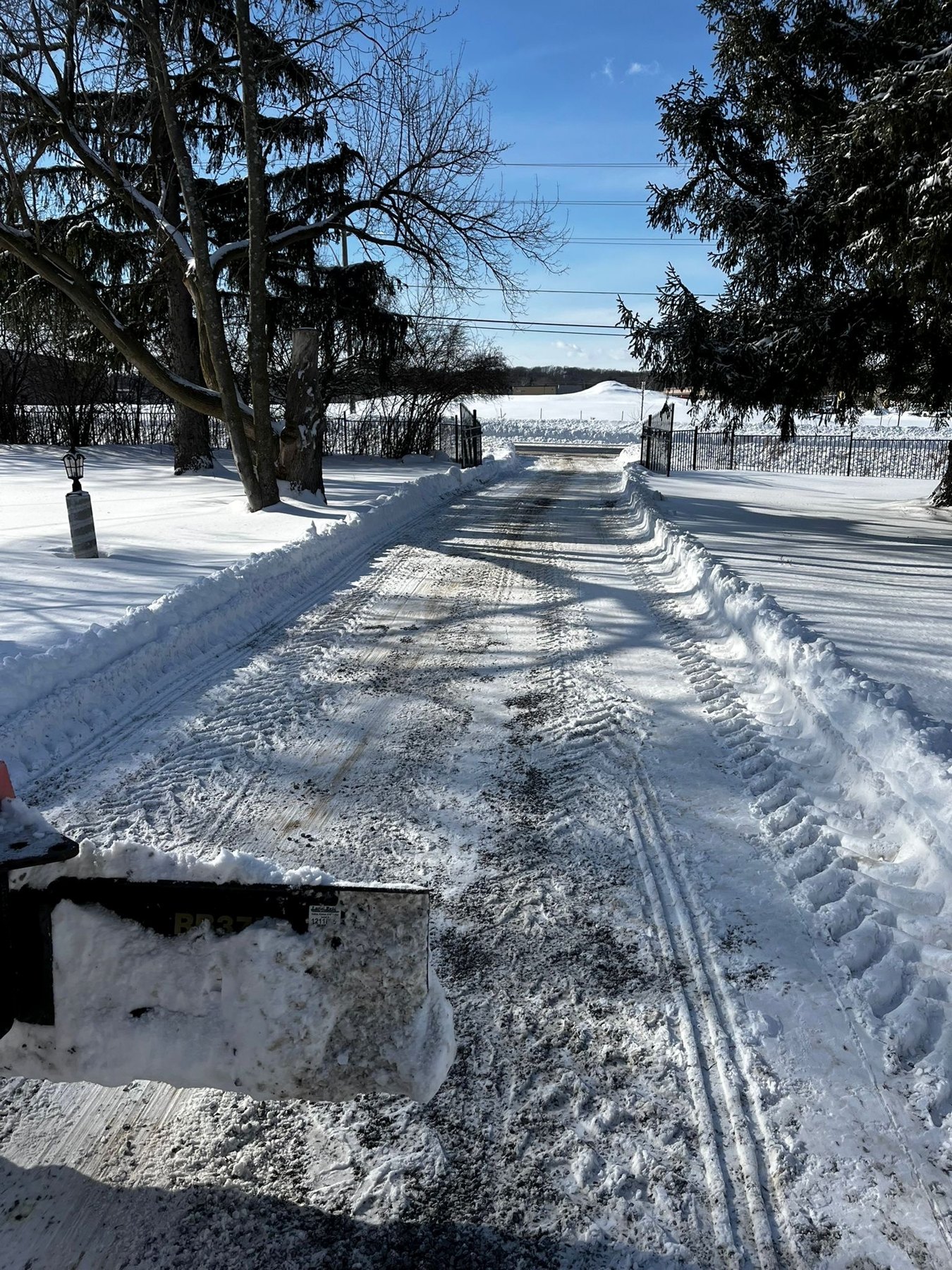 Cleared residential driveway with snowbanks along the sides